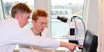 Bilde av Jens og Einar i mikrobiologilaben. De ser på bilde av sopp fra mikroskop .