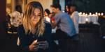 Young woman texting on phone at cafe