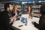 Fire kolleger i samtale rundt et bord i biblioteket