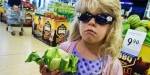 bilde av liten jente med solbriller i matbutikk. Hun holder en blomkål.