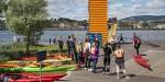 A group of kayakers on the docks gathered around their instructor and their kayaks. Photo: Benjamin A. Ward