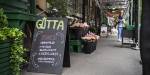 Flowers, produce and signs advertising different kinds of meat in front of Gutta på Haugen. Photo: Benjamin A. Ward