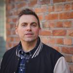 Mann står foran ein vegg.