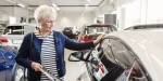 Old woman looking at a car.