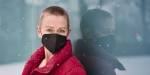 Ley Muller, master's student in social welfare, posing in a red jacket and black face mask.