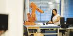 En student i robotikk og kybernetikk arbeider med en robot.