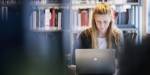 Blonde woman sitting in front of a laptop.