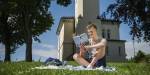 Simen reading a book and eating biscuits on the green grass. Photo: Benjamin A. Ward