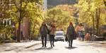 Three people walks down a street.