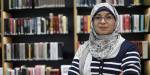 Close up of Rawia Awadallah in a library in front of big book shelves.