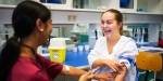 To bioingeniørstudenter øver på å ta blodprøve av hverandre.