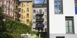 Colourful old apartment buildings with a lawn and sitting area outside.