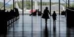 Silhouette of people at an airport departure hall.