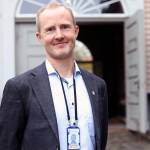 Nærbilde av Jon Jørgen Gudbrandsen foran en åpen tredør inn til Forsvarsmateriells bygning,