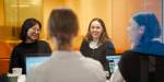 Fire studenter jobber sammen foran datamaskiner.
