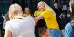 En kvinnelig fadder hilser med albuen på en ny student. Fadderen har på seg gul OsloMet- t-skjorte og smiler.