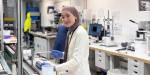 Sajida is analysing soil samples in the lab. We see laboratory equipment in the background.