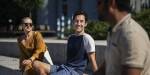 Austin and two friends relaxing on a bench in the sun.