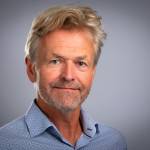 Portrait picture of researcher Jørn Holm-Hansen in a blue shirt facing the camera.