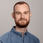 Portrettbilde av forsker Nils Arne Lindaas i blå skjorte som ser i kamera og smiler.
