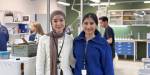 Portrait of Sajida and Maryam in the lab. Lab equipment and other students in the background.