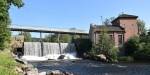 Small waterfall in Akerselva River with a bridge over it.