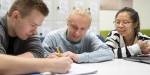 Three youths doing group work at school