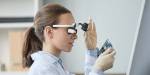 Girl wearing technology glasses and looking at technology model, in a bright room.