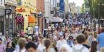 A crowd of people in a shopping street.