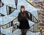 Julia standing in front of a graffiti wall.