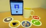 Picture of the tangible cup with all the five coasters and a tablet that shows what the user has just done.