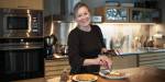 Forsker Annechen Bahr Bugge river brunost over iskrem på kjøkkenet.
