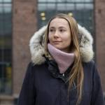 Visiting researcher Oleksandra Deineko wearing a winter coat in front of a brick building at OsloMet campus.