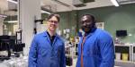 Fredrik and Jacob in the lab, wearing blue coats. Lab equipment in the background.