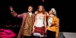 Tre studenter i flotte, gammeldagse kostymer har teaterfremføring på en scene.