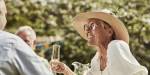 Older woman drinking from a champagne glass.