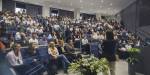 En foreleser foran en gruppe studenter i et auditorium.