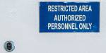 Photo of a blue sign on a locked, grey door, with the text Restricted area, authorized personnel only. Photo: Unsplash