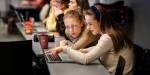 To bachelorstudenter i økonomi og administrasjon ser sammen på en laptop i et undervisningsrom.
