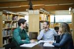 Tre kolleger i samtale på biblioteket 